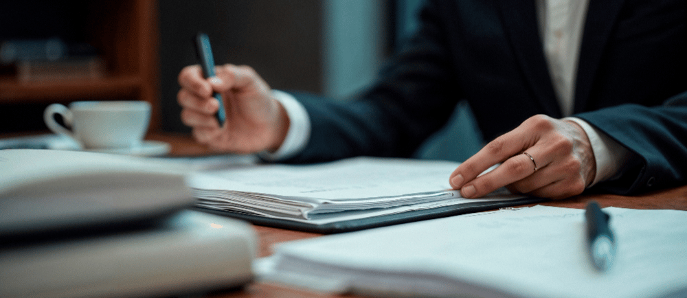 Advogado tributário fazendo anotações em papel em uma mesa