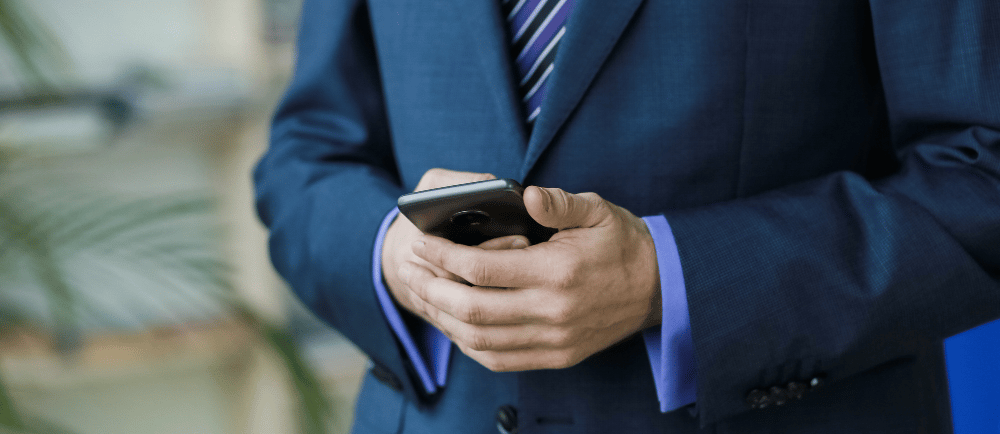 Advogado de terno com o celular na mão
