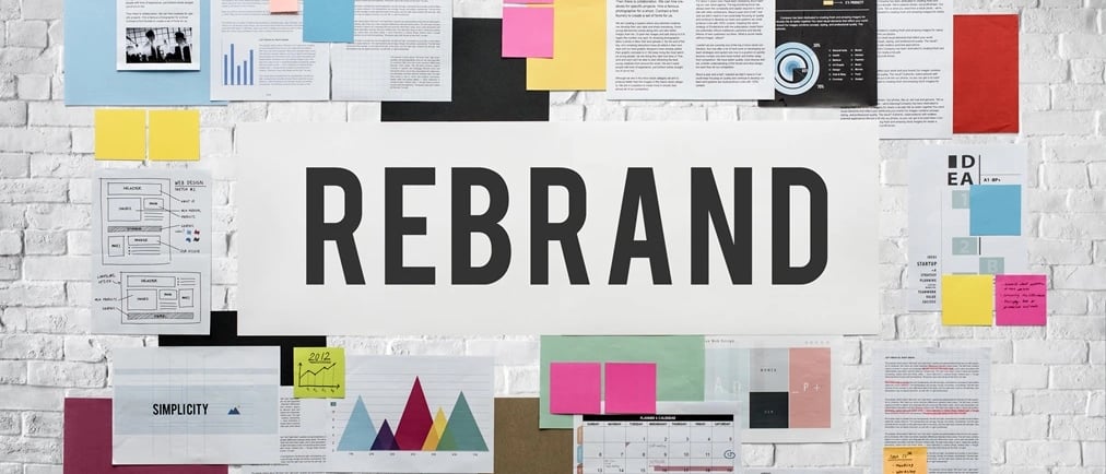 Palavra "Rebrand" e colagem de papéis indicando trabalho de design