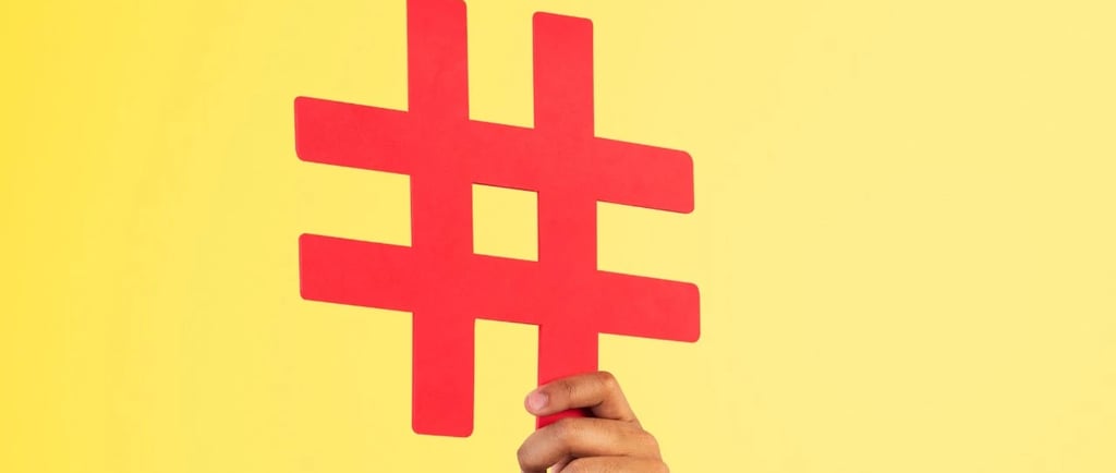 Uma mão segurando uma hashtag com um fundo amarelo