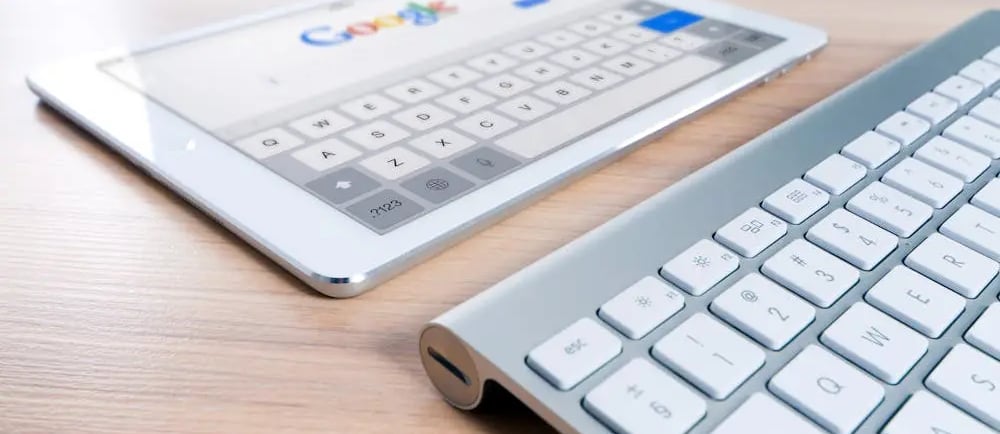Teclado e tablet com a página inicial do Google