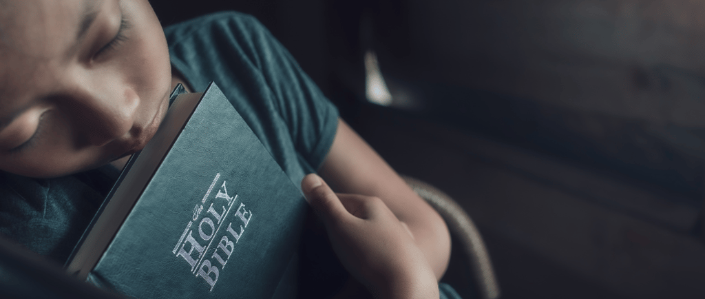 Garçon qui dort avec une bible 