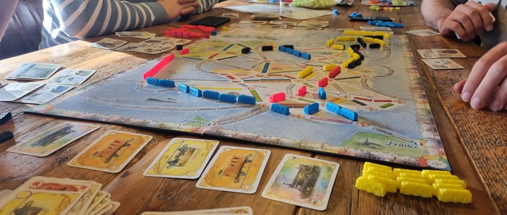 Een tafel met het bordspel Ticket to Ride