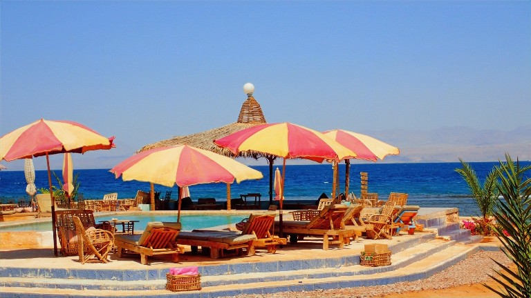 una spiaggia in Egitto con piscina vista mare, attrezzata con ombrelloni e sdraio