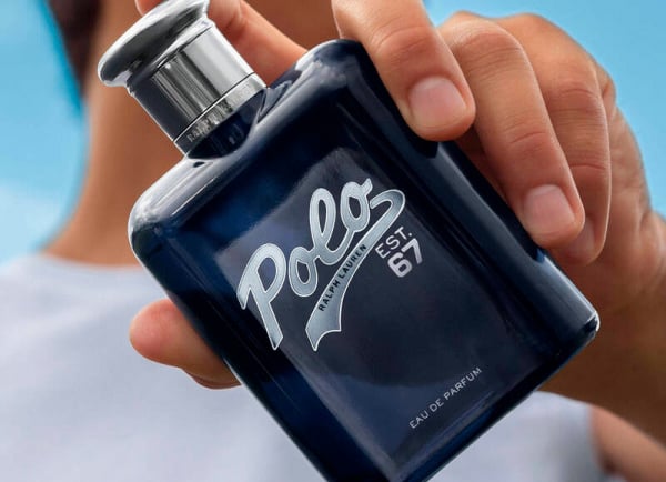 Hand holding a bottle of Ralph Lauren Polo Est. 67 Eau de Parfum men's fragrance.