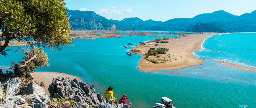 a group of people standing on a cliff overlooking Iztuzu Beach