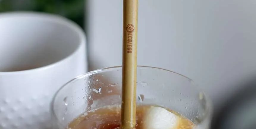 a cup of milk with  honey and a strawberries