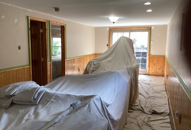 a room with drop clothes covering furinture