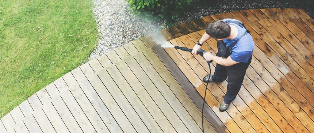 a man is using a pressurer washer to clean a deck