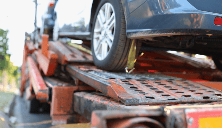 Small sedan loaded on a flatbed tow truck after being stranded on I-15.