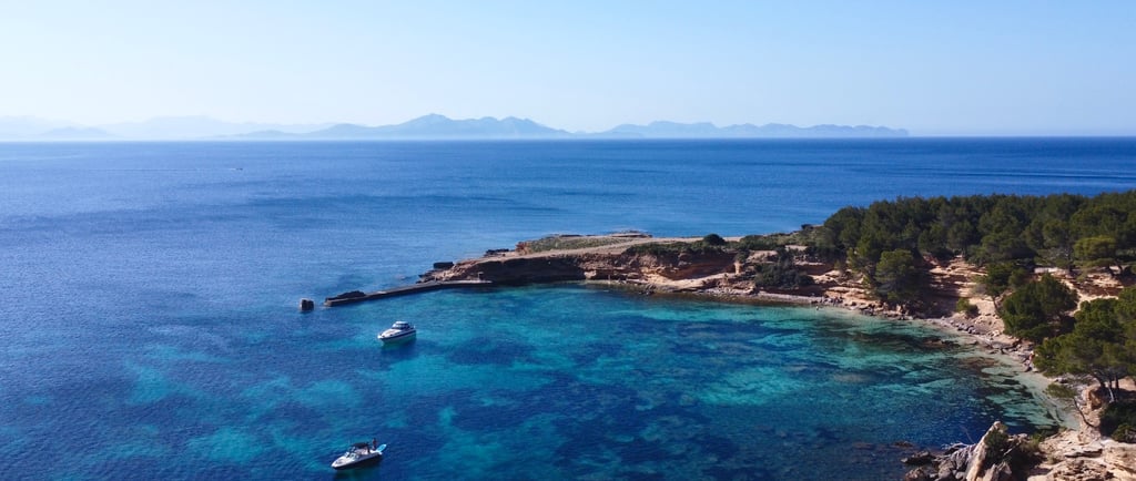 Private boat sailing in crystal-clear waters on the northern coast of Mallorca, Alcudia.