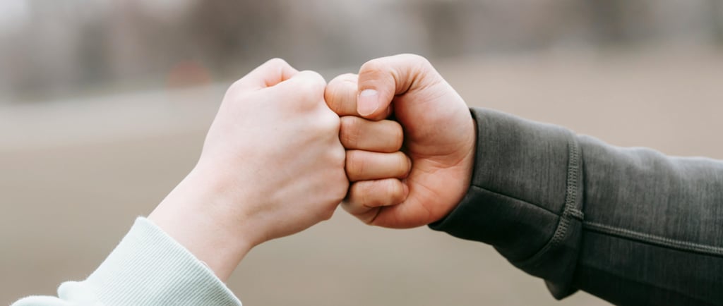 two trusting friends fist-bumping