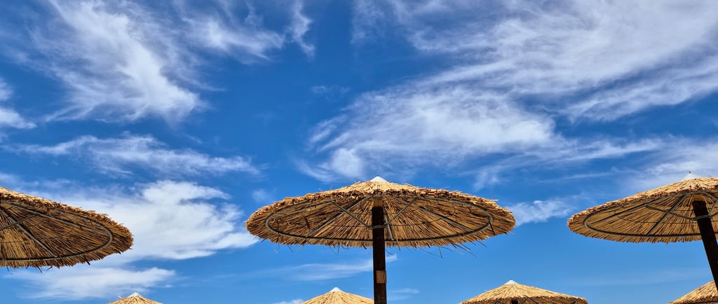 am Strand mit Sonnenschirmen