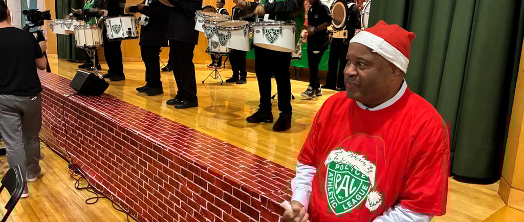 Child advocate and author Dominic Carter wearing a red Santa hat and red PAL Christmas shirt