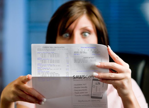 woman shockingly looking at a high water bill