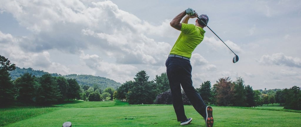 A man hitting a golf ball on a golf fairway