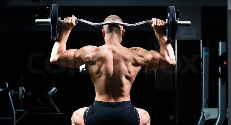 a man doing a back - up on a bench with a barbell