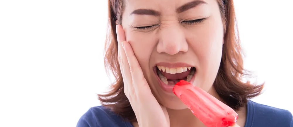 a woman with hands on cheek and mouth open with icecream on one hand