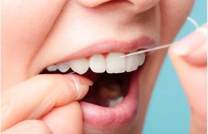 a image showing floss thread inserted between upper right anterior teeth