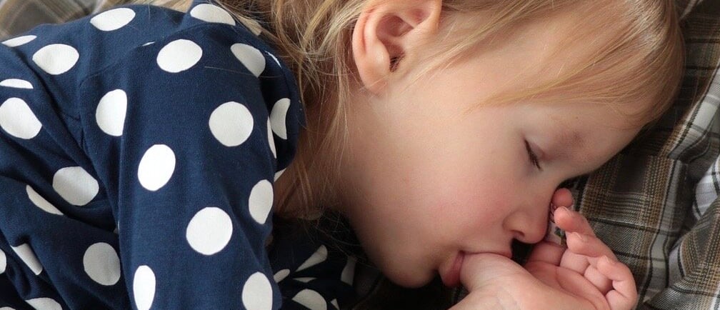 a kid sucking thumb in sleep