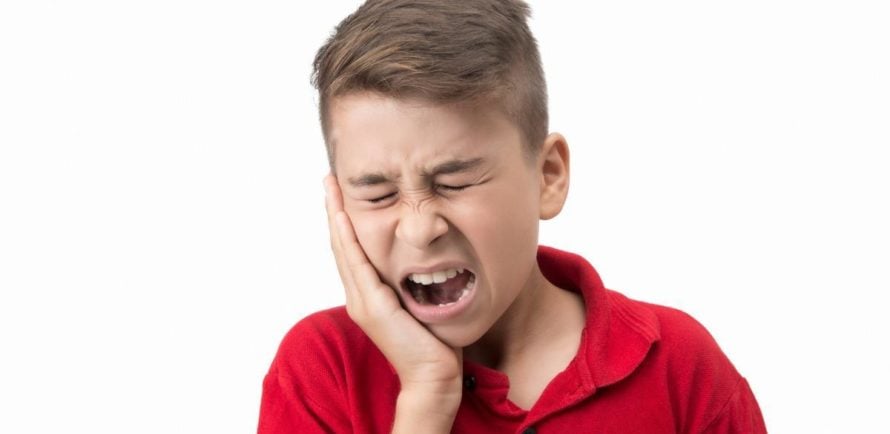 a boy holding hands in cheek with severe toothache