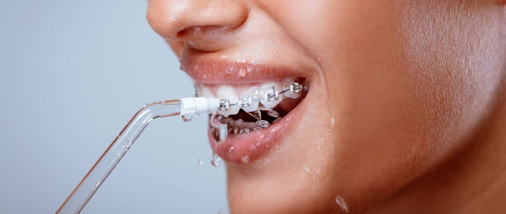 a woman using water flosser in mouth
