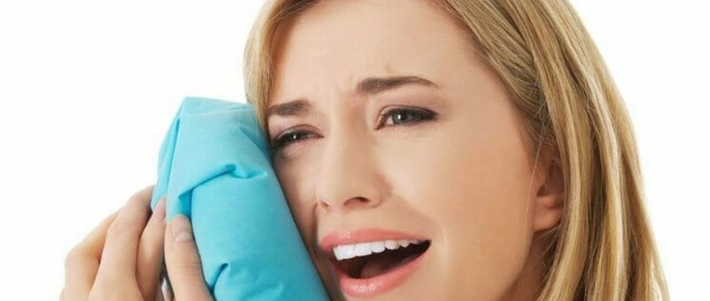 a women keeping bluewrapped ice cloth on cheeks