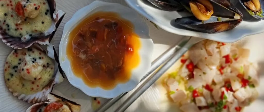 Fresh seafood platter with steamed mussels, baked scallops in shells, and white fish ceviche served with lemon.