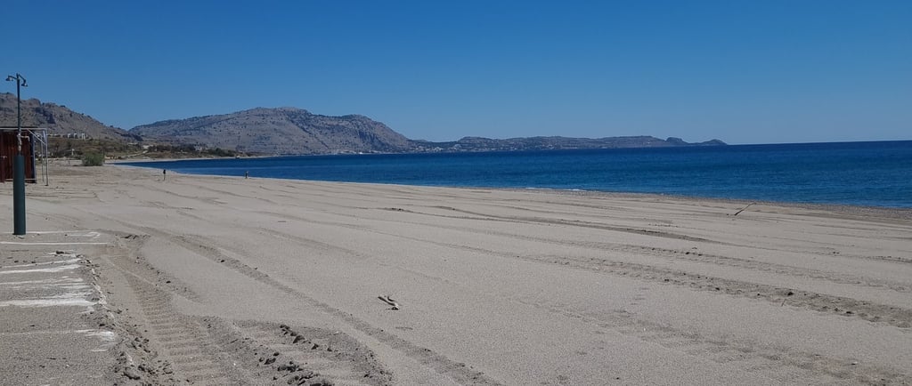 a beach with sand and blue water