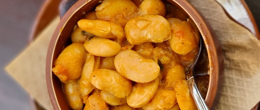 a bowl of beans and a spoon on a plate