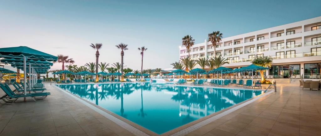 Luxury beachfront resort with a large outdoor swimming pool, lounge chairs at Mitsis Faliraki Beach 