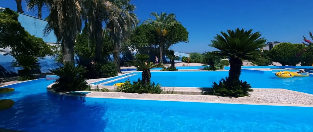 a pool with a blue sky and palm trees in Faliraki Waterpark Rhodes Greece