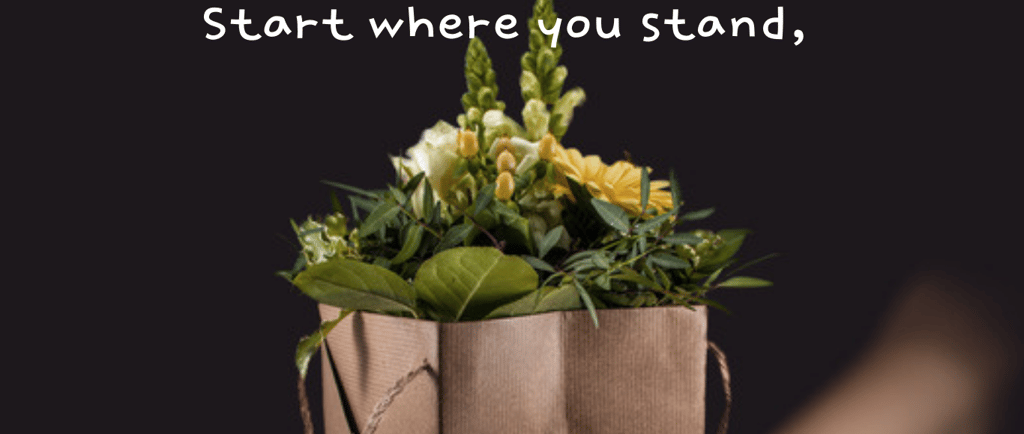 a person holding a paper bag with flowers