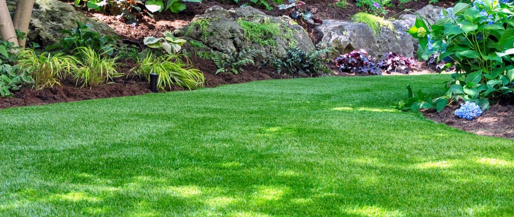 a lush green lawn with a stone wall and a stone wall
