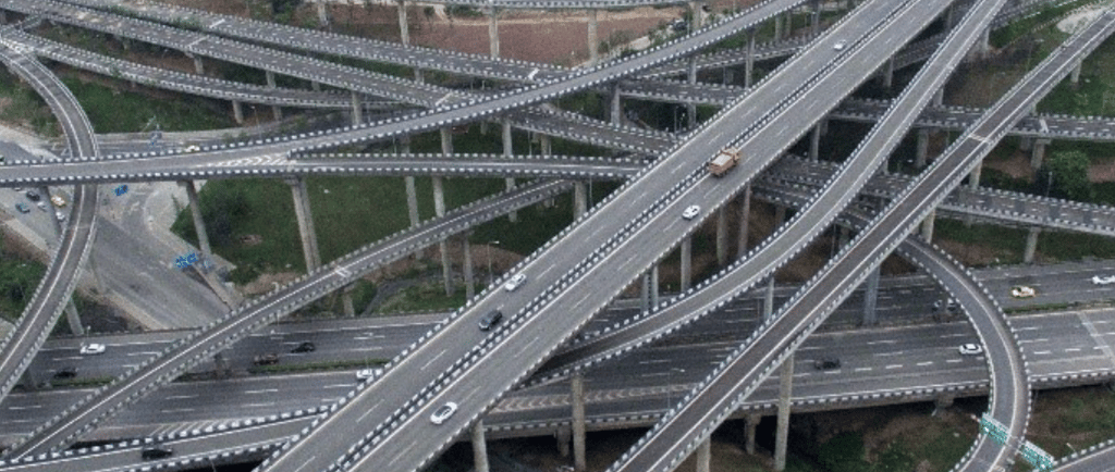 a large group of cars driving through a large intersection