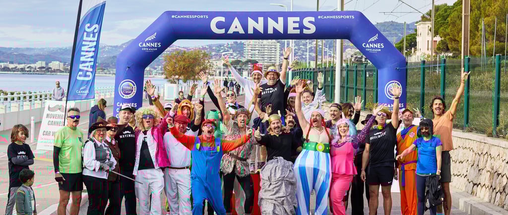 a group of people standing in front of a sign that says cannes for movember