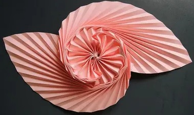 Origami artistico rosa su sfondo grigio 