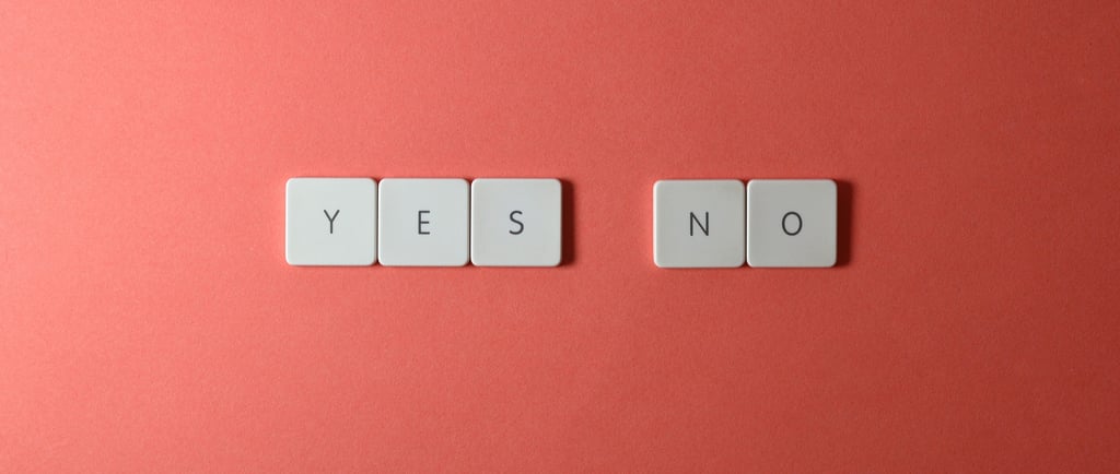 White tiles similar to scrabble tiles spelling out the words yes and no on a red background