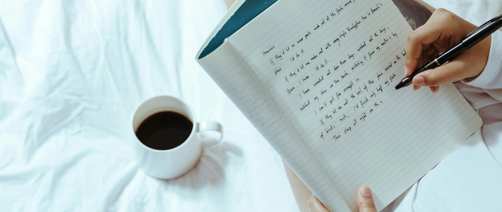 Imagem de um caderno com algumas coisas escritas, uma mão segurando uma caneta e uma caneca de café 