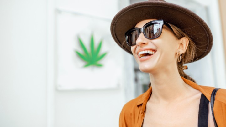 a woman in a hat and sunglasses smiling