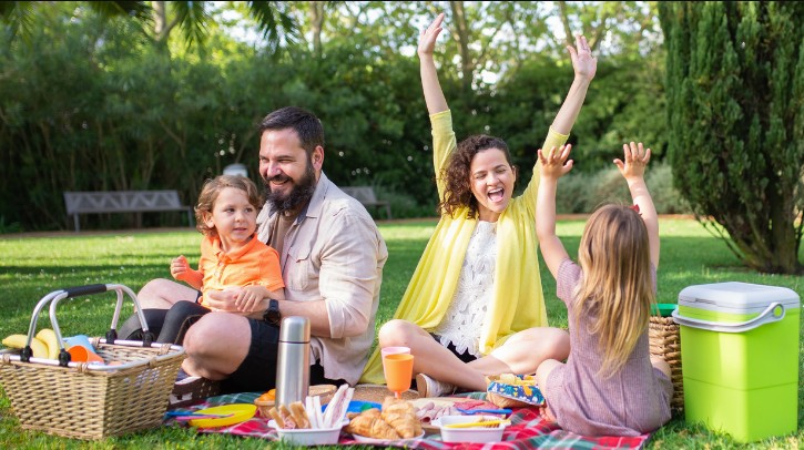 a family of four people sitting on a blanket
