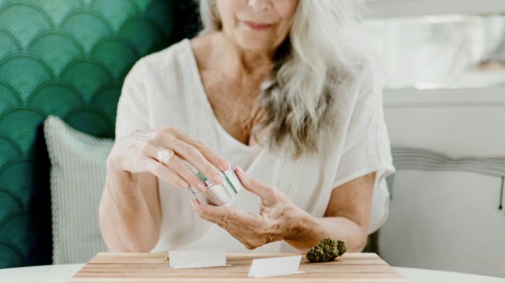 a woman in a white shirt is holding a piece of food