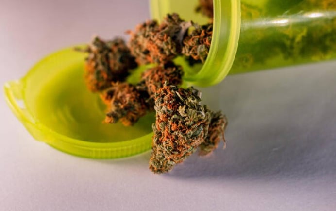 a green bottle of marijuana marijuana in a green container