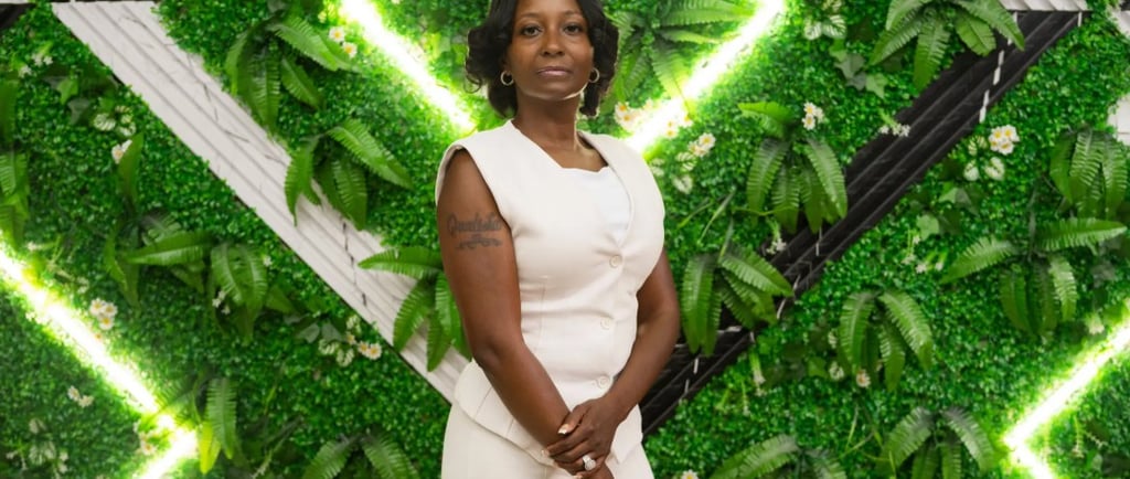 a woman in a white dress and a green wall with a green wall behind her