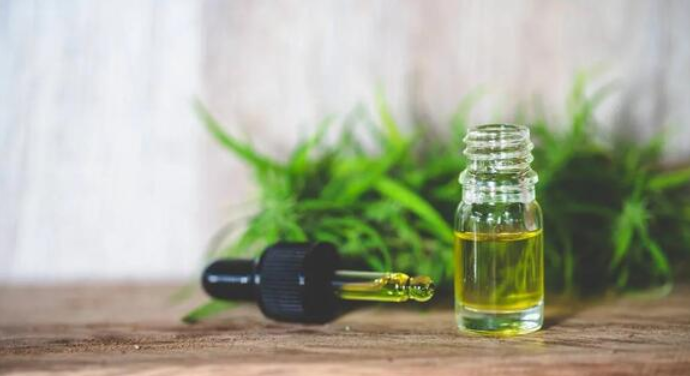 a bottle of oil with a plant in the background