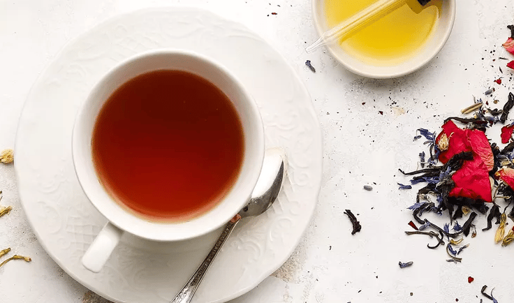a cup of tea and a spoon on a plate