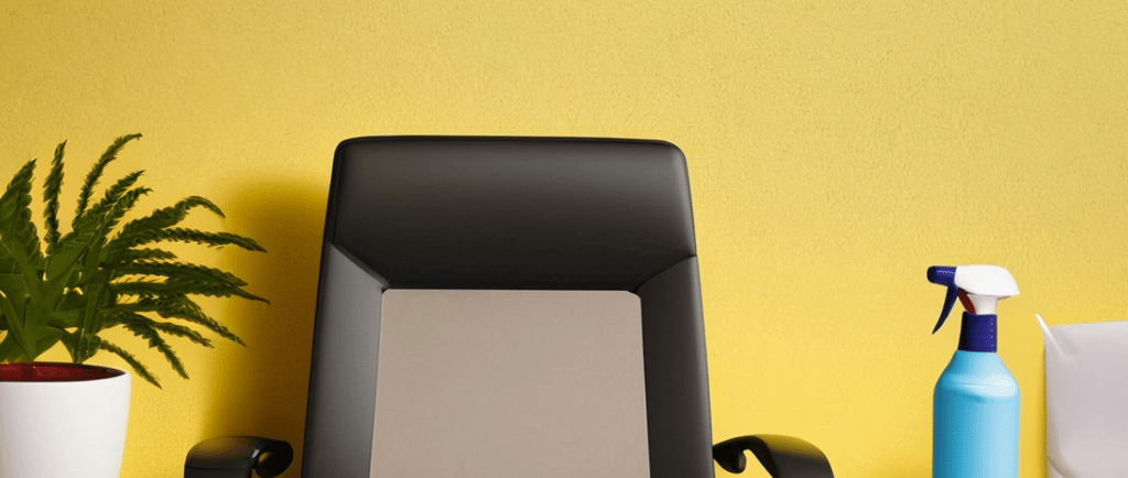 a desk with a chair and a plant in front of a yellow wall