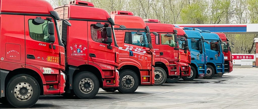 Red and Blue Trucks Parked at a Depot
