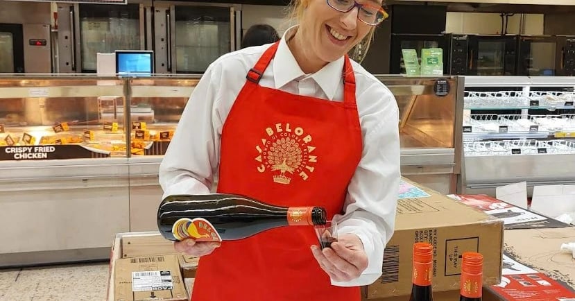 A woman in a red apron and a red apron. Morrisons Launches In-Store Sampling to Enhance Customer Exp