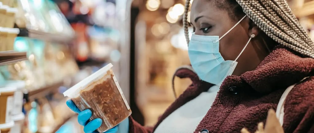 changing frozen food trends; a woman in a mask and gloves holding a piece of bread